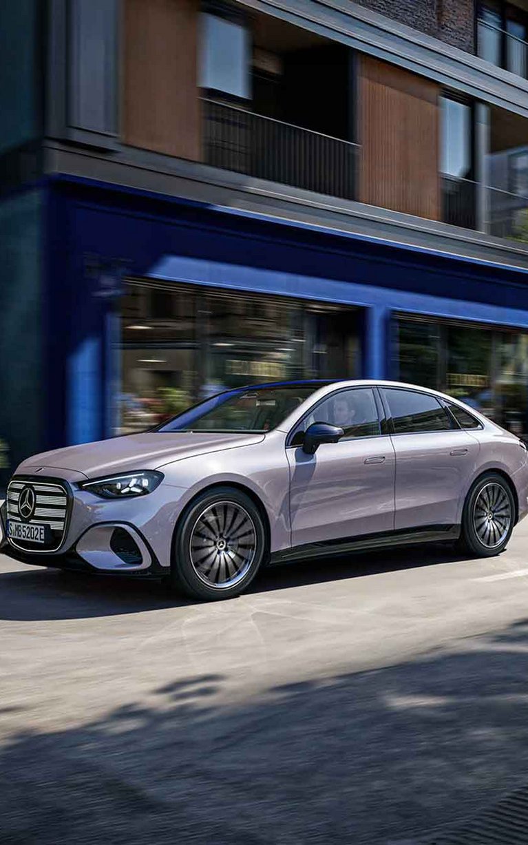 Die neue vollelektrische Mercedes-Benz C-Klasse fährt durch eine moderne Innenstadt und kombiniert elegantes Design mit innovativer Elektromobilität.