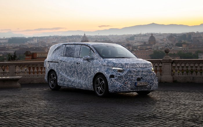 Getarnter Mercedes-Benz VLE Prototyp steht bei Sonnenuntergang vor der Skyline von Rom während Testfahrten.