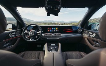 Blick in den Innenraum eines Mercedes-Benz GLE AMG mit eingeschalteten Displays und roter Ambientebeleuchtung.