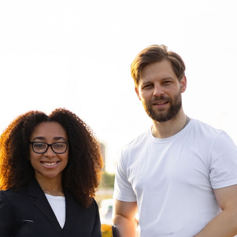 Zwei Personen nutzen ein Tablet zur digitalen Fahrzeugsuche auf einem Autohaus-Gelände