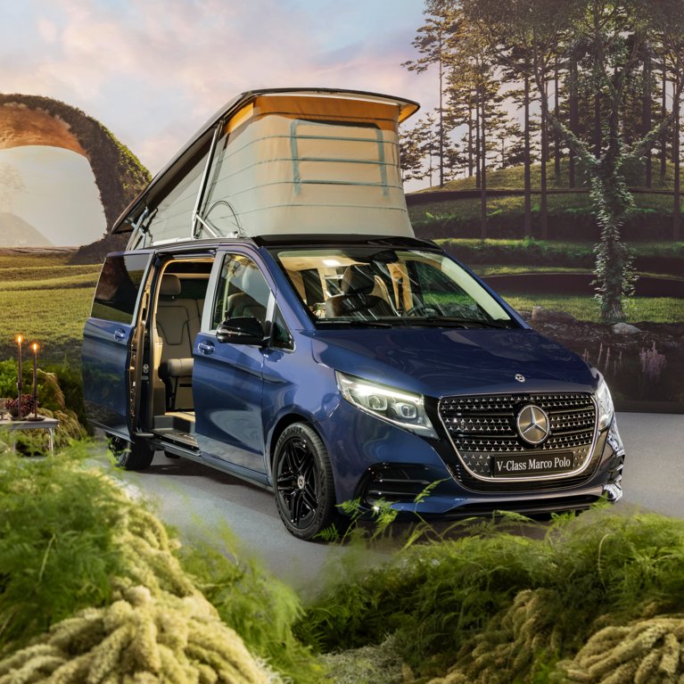 Ein blauer Mercedes-Benz Marco Polo mit geöffnetem Aufstelldach steht inmitten einer idyllischen Landschaft. Campingstühle und Tisch sind aufgebaut – Symbol für Reisen, Abenteuer und Flexibilität mit Mercedes-Benz Rent bei S&G.