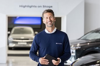 Berater im Hyundai Autohaus mit Fahrzeugen im Hintergrund – Symbolbild für persönliche Beratung und attraktive Finanzierungsangebote bei S&G.