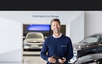 Berater im Hyundai Autohaus mit Fahrzeugen im Hintergrund – Symbolbild für persönliche Beratung und attraktive Finanzierungsangebote bei S&G.