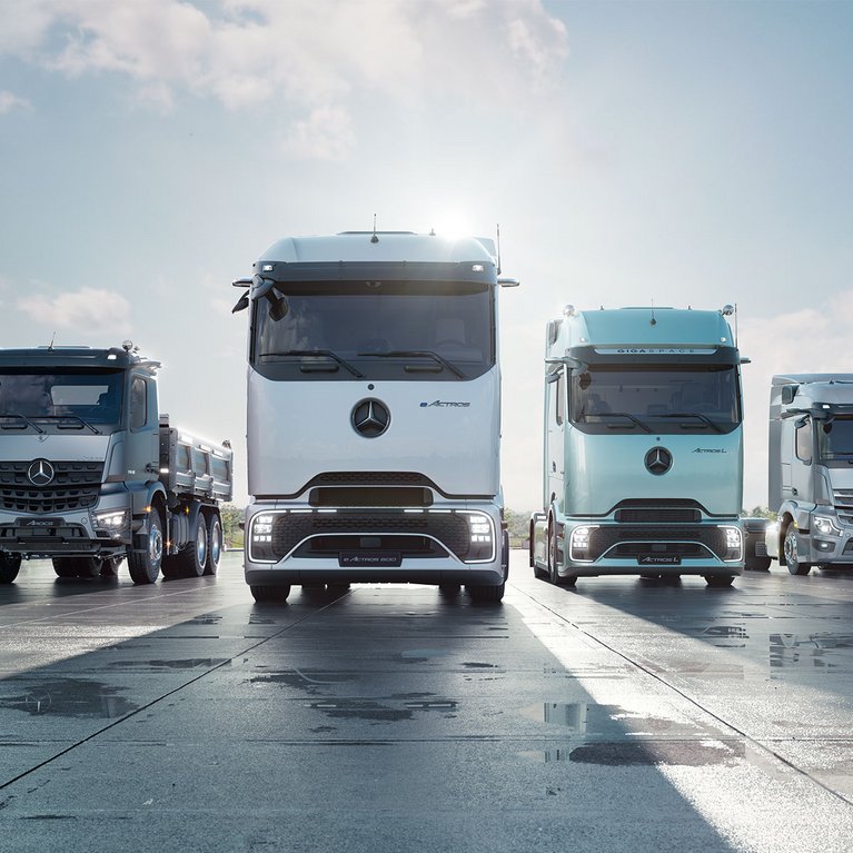 Mehrere moderne Mercedes-Benz Lkw, darunter auch vollelektrische Modelle, stehen aufgereiht vor einem Werk – Symbol für die BALM-Förderung von umweltfreundlichen und sicheren Transportlösungen 2025.