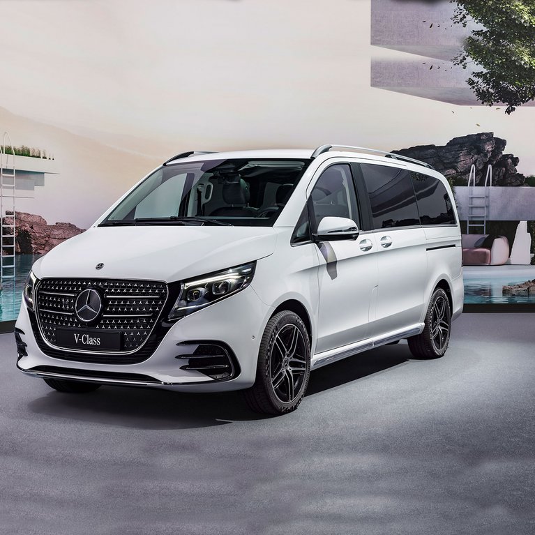 Eine weiße Mercedes-Benz V-Klasse steht stilvoll in moderner Umgebung. Das Fahrzeug verkörpert Premium-Komfort, großzügigen Platz und Flexibilität mit Mercedes-Benz Rent bei S&G.
