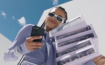 Junge Frau mit Smartphone und futuristischem Look – Mercedes-Benz Aktion: 20 % Rabatt auf digitale Extras für Ihr Fahrzeug.