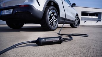 Dekorationsbild für den Mercedes-Benz Zubehör-Konfigurator mit einem elektrischen Mercedes-Benz Modell dessen Ladekabel auf dem Boden liegt.