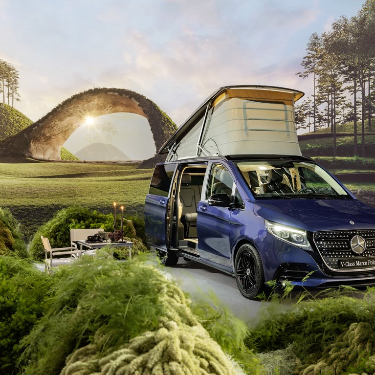Ein blauer Mercedes-Benz Marco Polo mit geöffnetem Aufstelldach steht inmitten einer idyllischen Landschaft. Campingstühle und Tisch sind aufgebaut – Symbol für Reisen, Abenteuer und Flexibilität mit Mercedes-Benz Rent bei S&G.