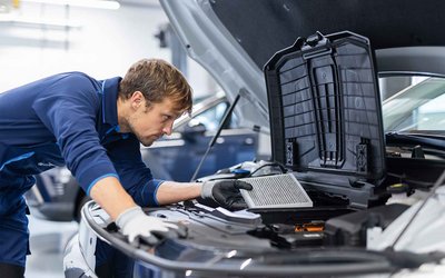 Kfz-Mechatroniker untersucht den Motor eines Hyundai Pkw bei S&G Ihrem Hyundai Servicepartner.