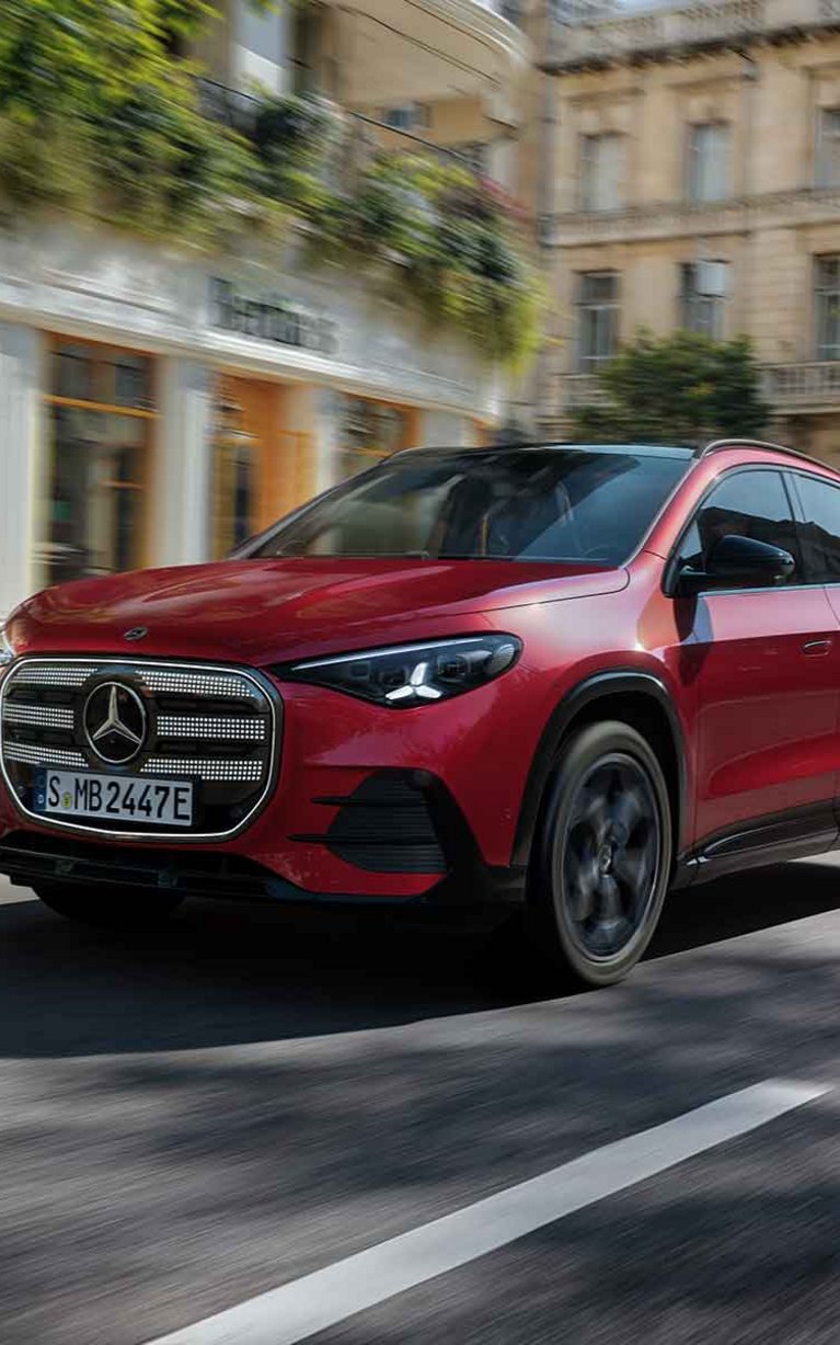 Roter Mercedes-Benz GLA fährt auf einer Straße durch die Stadt.