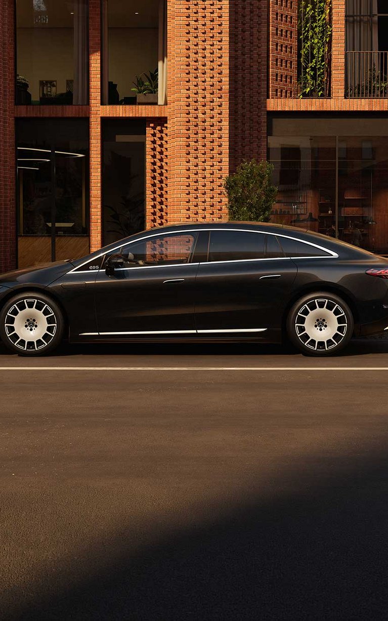 Der neue Mercedes-Benz EQS seitenansicht, schwarz vor einem modernen Haus.