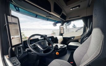 Innenansicht des Mercedes-Benz eActros 400 mit digitalem Cockpit, Multifunktionslenkrad und ergonomisch gestaltetem Fahrerarbeitsplatz für komfortables und effizientes Fahren