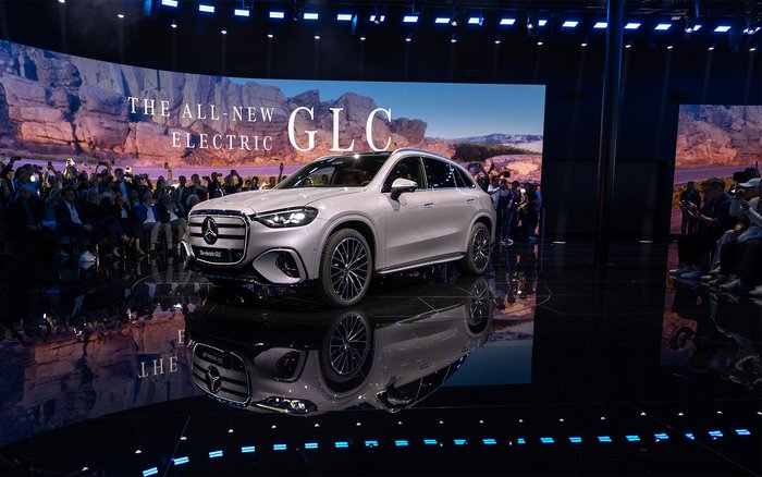 Der neue vollelektrische Mercedes-Benz GLC bei seiner Präsentation auf einer Bühne mit großem LED-Display im Hintergrund.