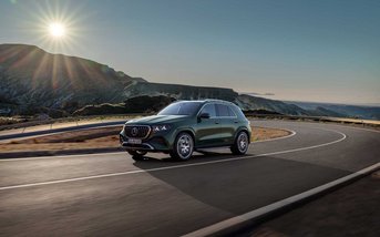 GLE AMG SUV fährt auf kurviger Straße mit Sonne im Hintergrund