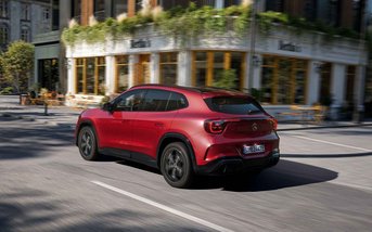 Heckansicht eines roten Mercedes-Benz GLA bei der Fahrt durch die Innenstadt.